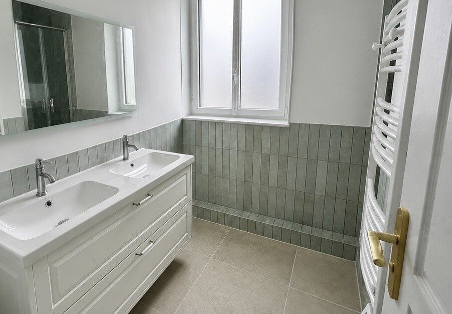 Autre salle de bain après rénovation : faïence verte, double vasque, sèche-serviette