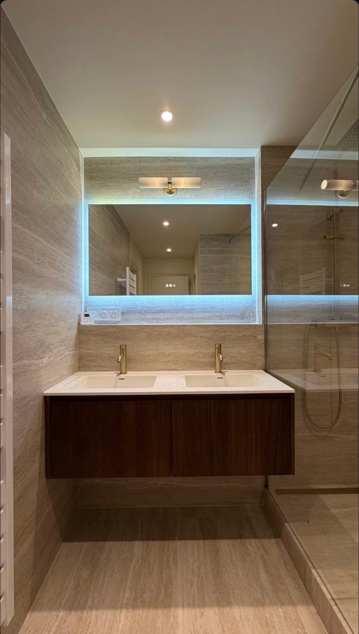Salle de bain du projet Paris 12 : double vasque en bois, grand miroir lumineux et douche italienne