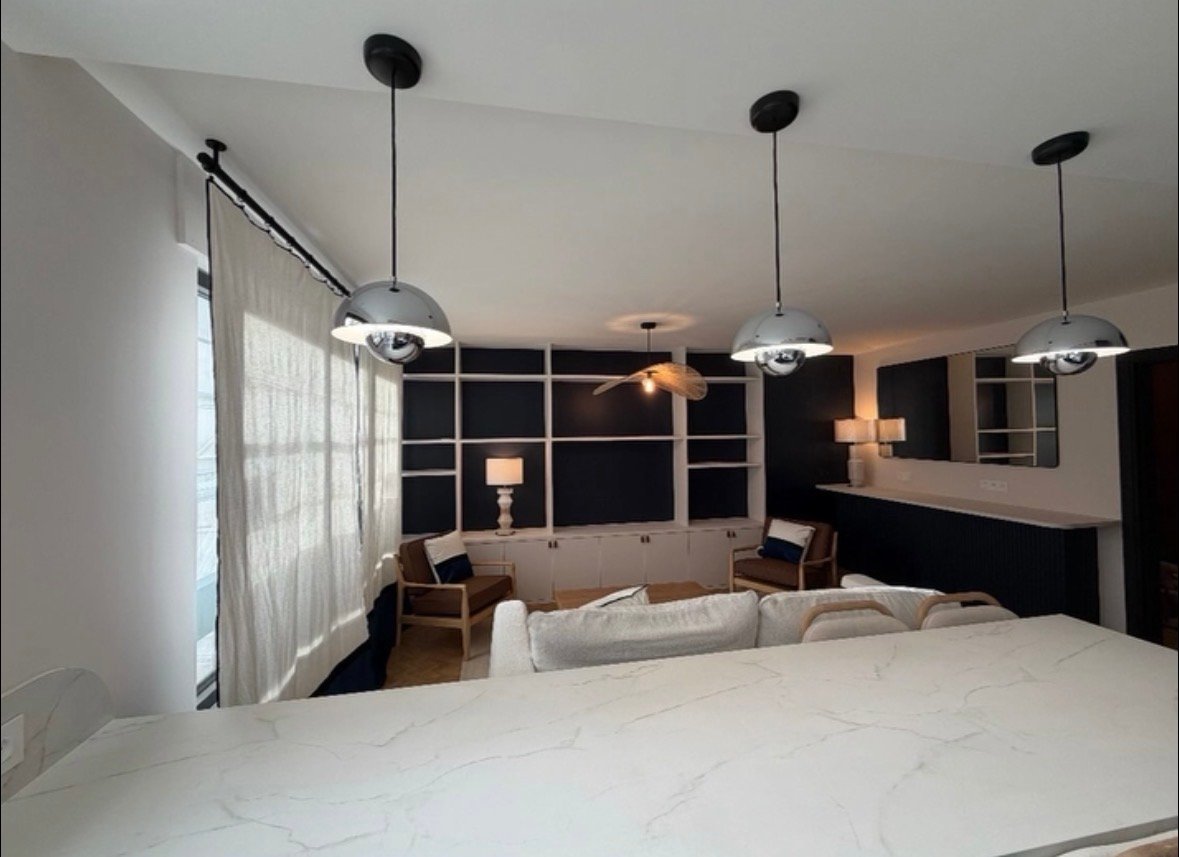 Salle de vie du projet Paris 12 vue depuis le bar de la cuisine, suspensions dômes chromées