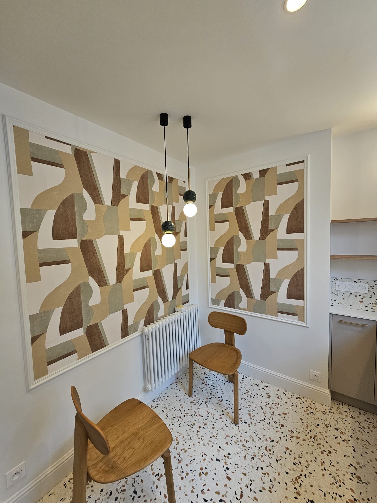 Salle à manger avec papier peint géométrique et suspension double