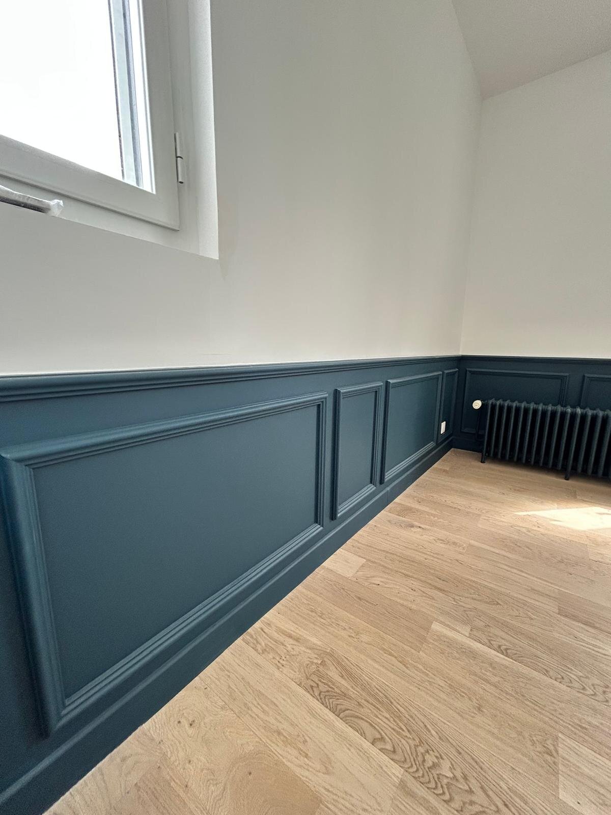 Pièce avec cimaises bleu canard sous fenêtre
